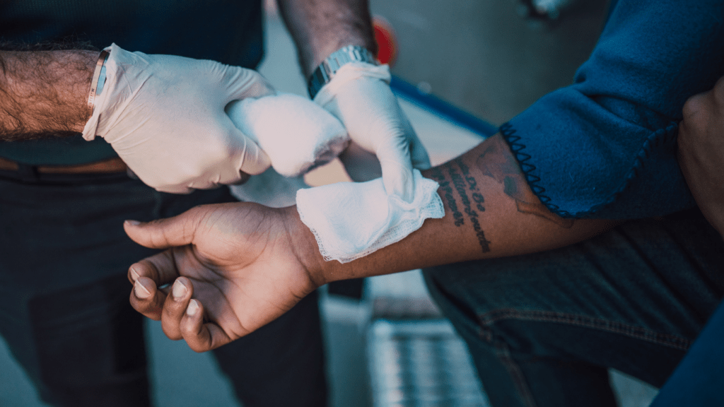 A person getting their arm bandaged by another person