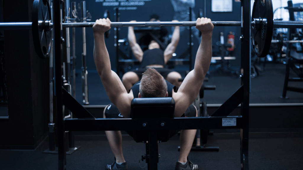 A person is doing a bench press in a gym
