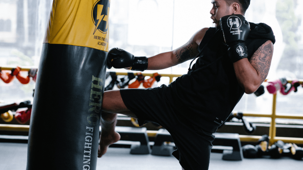 A person punching a punching bag in a gym