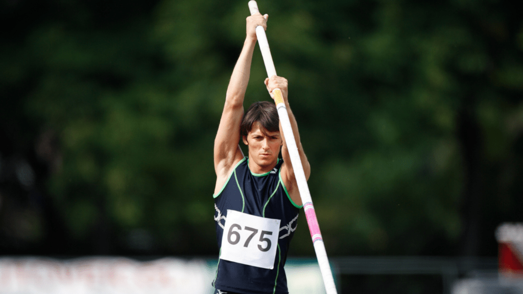 A pole vaulter holding a pole in the air