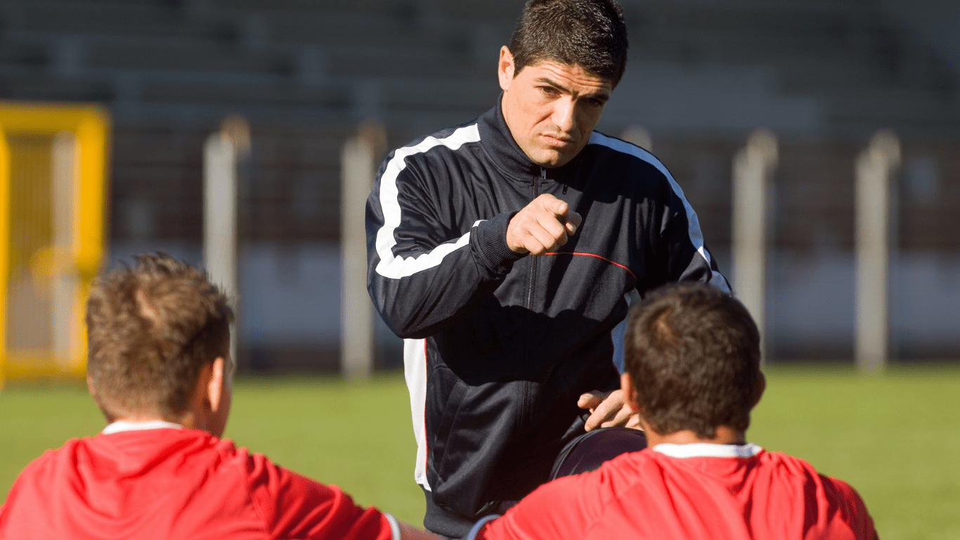 a soccer coach talking to players on the field