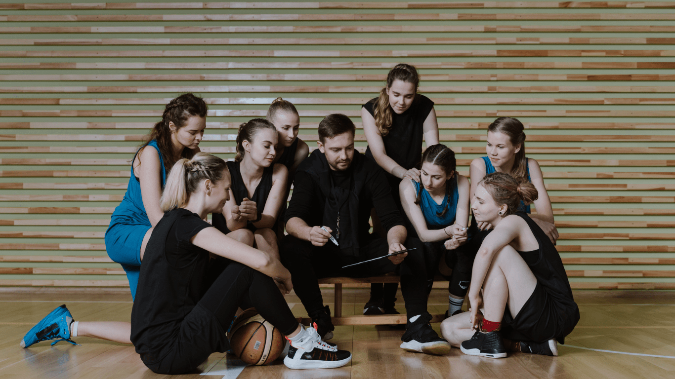 a group of people sitting on a basketball court