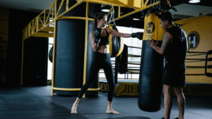 A person punching a punching bag in a gym