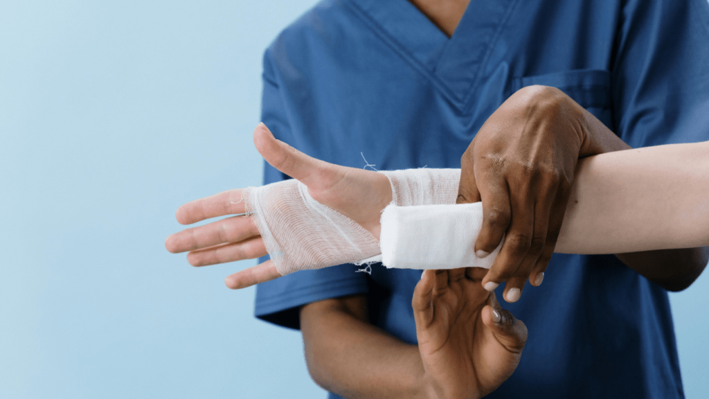 A person getting their arm bandaged by another person