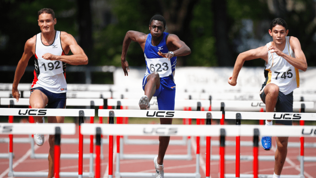 a person jumping over an obstacle on the field