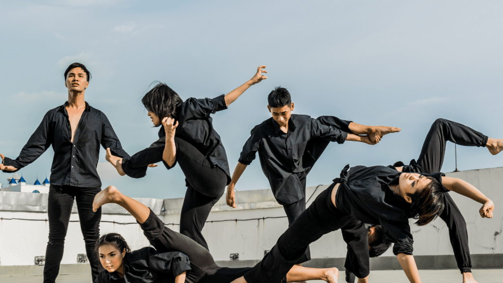 a group of people doing a dance in front of a building