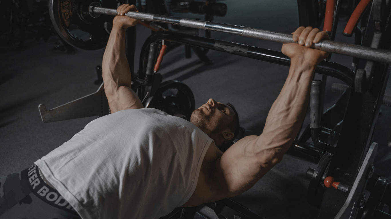 A person is doing a bench press in a gym