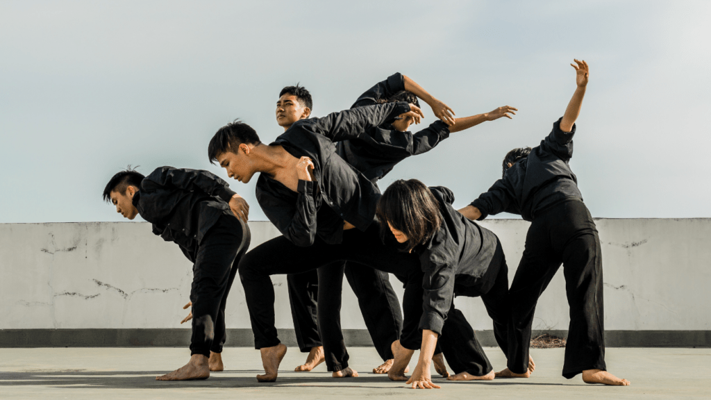 a group of people doing a dance in front of a building