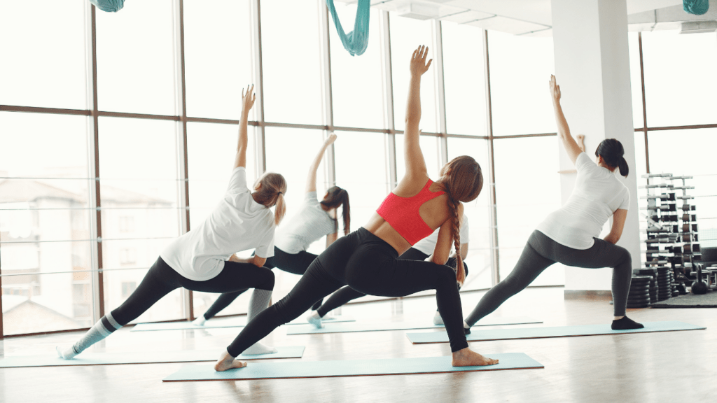 a group of people doing yoga in a gym