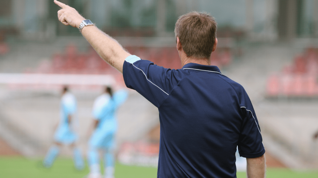 soccer coach pointing to the referee
