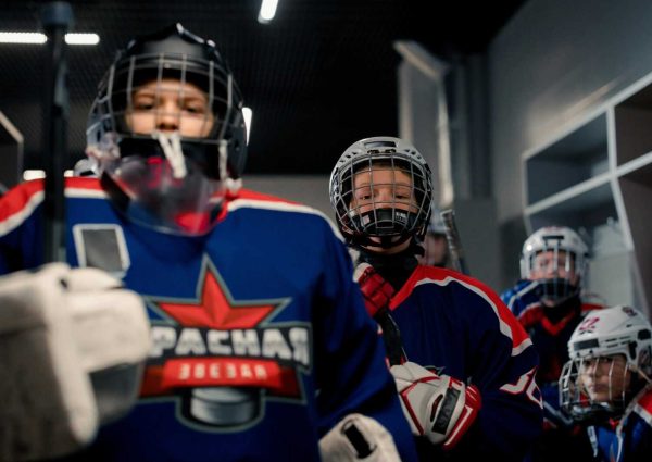 pexels-photo-8972141-8972141 Youth hockey players in full gear, ready for a game in the locker room.